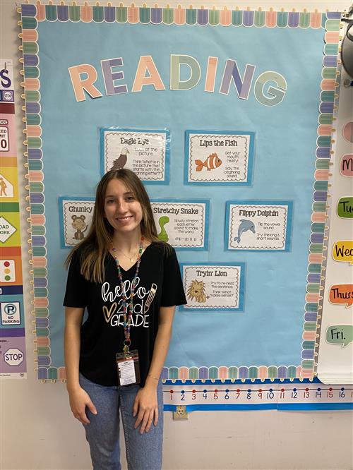 Ms. Bartleman by her reading bulletin board