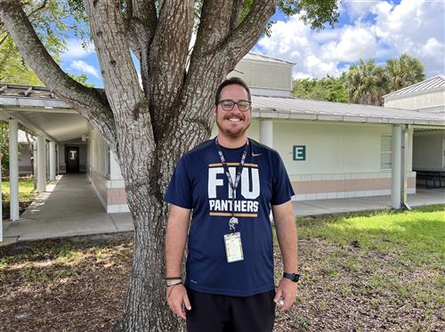 Mr. Fernandez wearing an FIU Panthers T-Shirt standing in the courtyard
