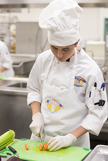 A student working in the kitchen for the commercial foods class A student working in the kitchen for the commercial foods class