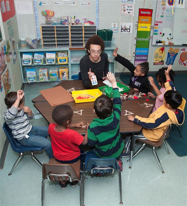 A Student Helping the teacher teach little kids in the teacher assistant class A Student Helping the teacher teach little kids in the teacher assistant class