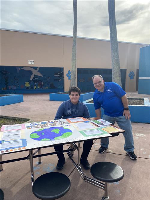 Mr. Benick and student with display board