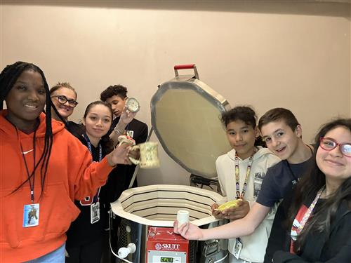 art students with pottery and kiln